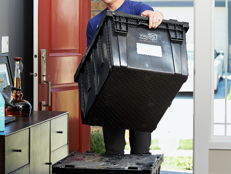 Person using Vaultra Storage moving bins to pack and organize items