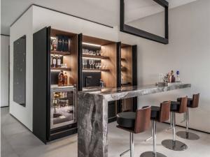 Seven creative ways to build a minibar at home, including using a bar cart, converting a cabinet, installing floating shelves, repurposing a corner nook, adding stylish glassware displays, incorporating a wine rack, and creating a dedicated countertop space for mixing drinks.