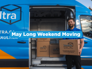 Vaultra mover holding a box in front of a Vaultra Storage moving van